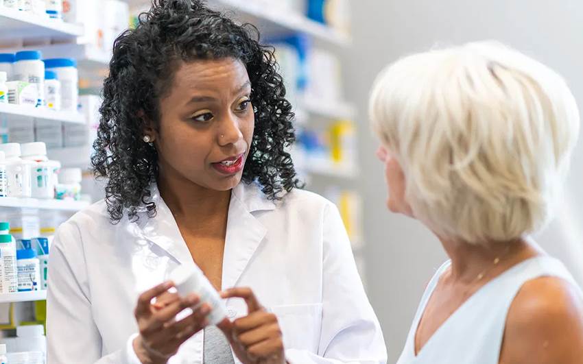 خانمی که در حال مشاوره گرفتن از متصددی داروخانه است