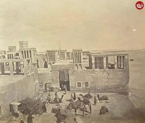 کارگران جنوبی در حال خالی کردن بار شترها در بندر لنگه؛ سال ۱۲۸۸